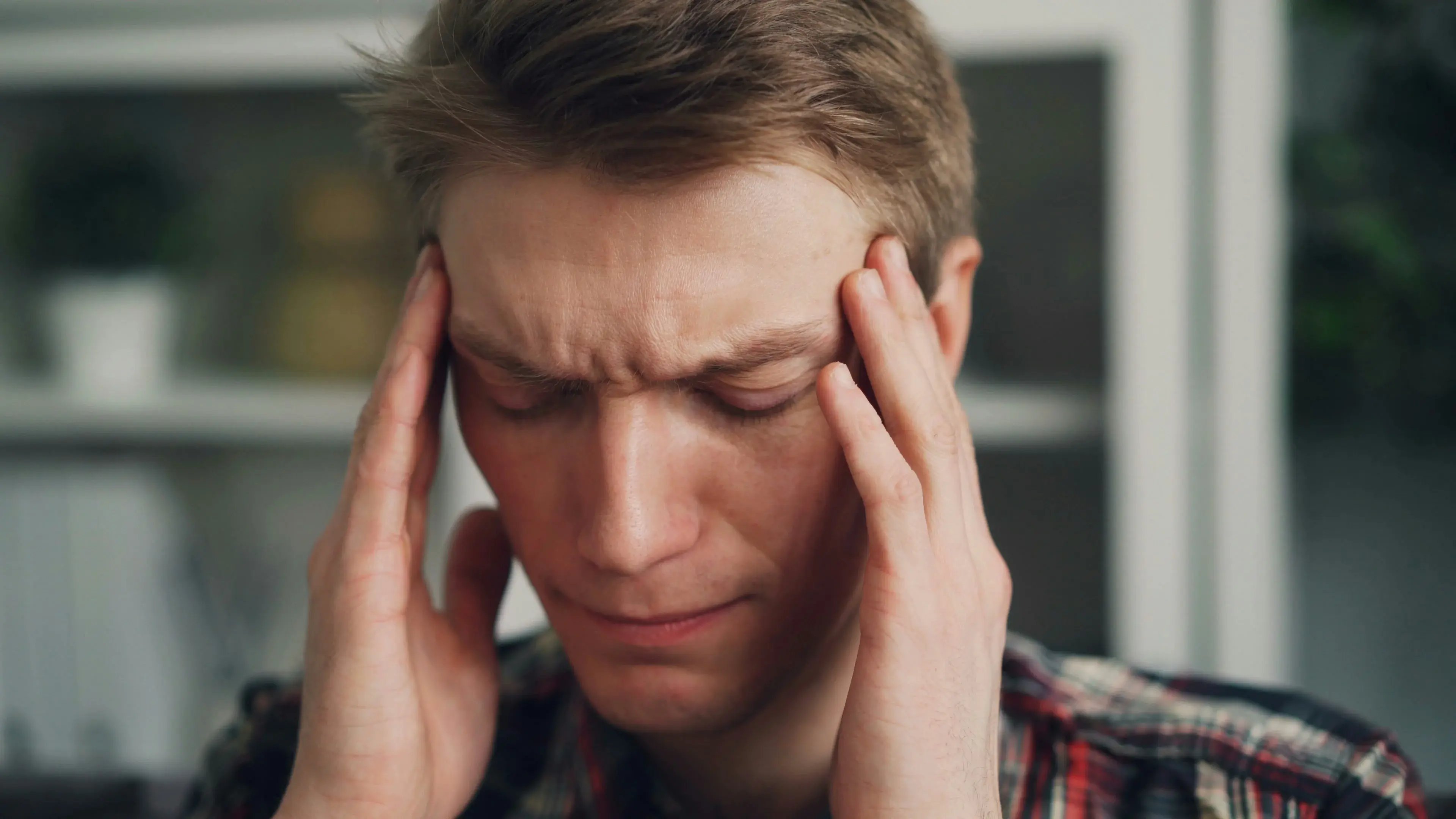 Close up of man holding head in pain from constant migraines