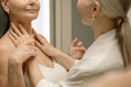 woman rubbing cream on neck