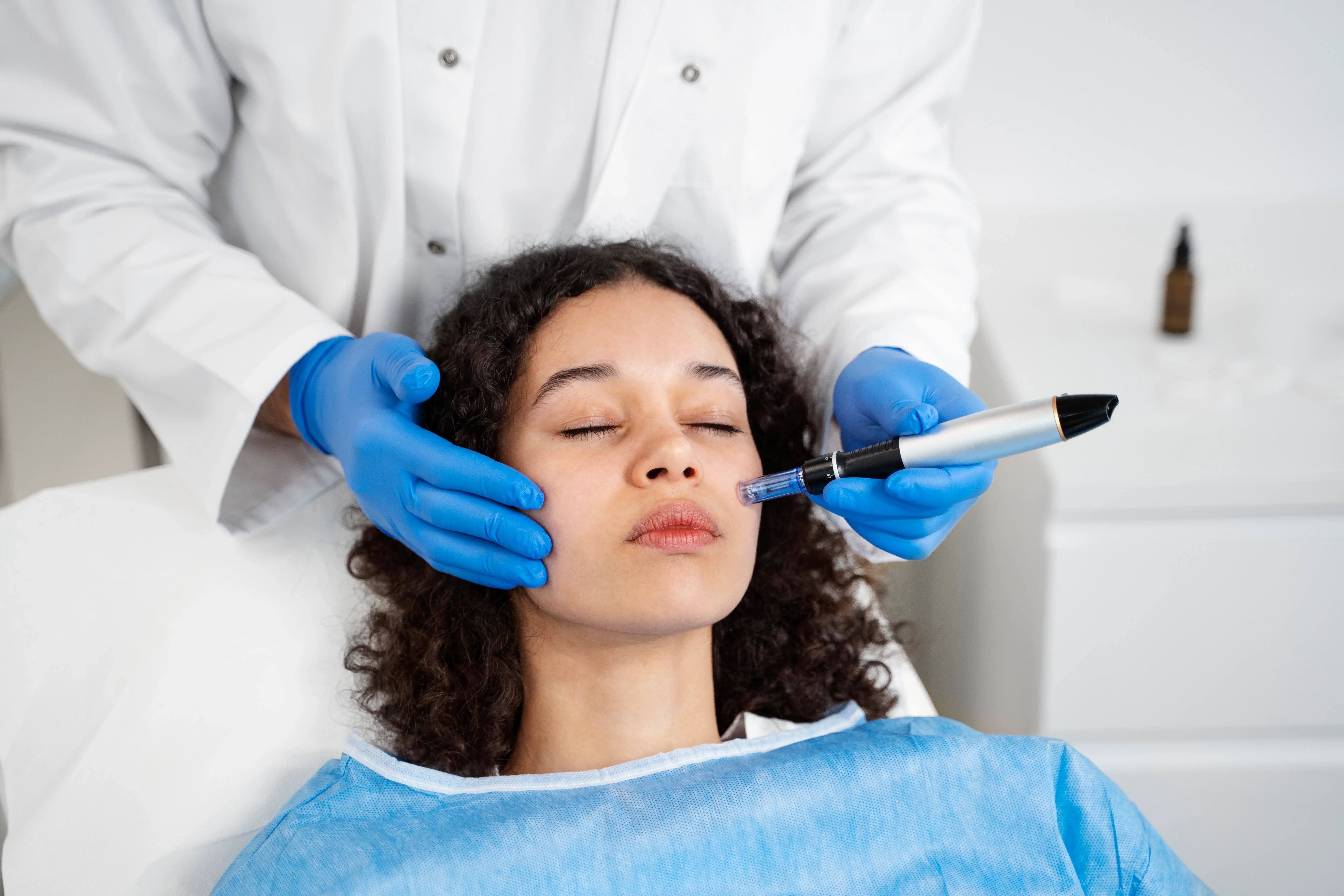 doctor conducting microneedling procedure on patient